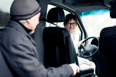 senior man sitting in paratransit van with his nurse