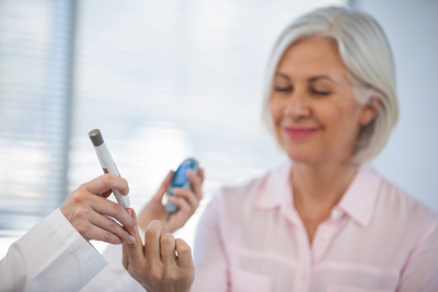 doctor checking glucose level in diabetic patient in clinic